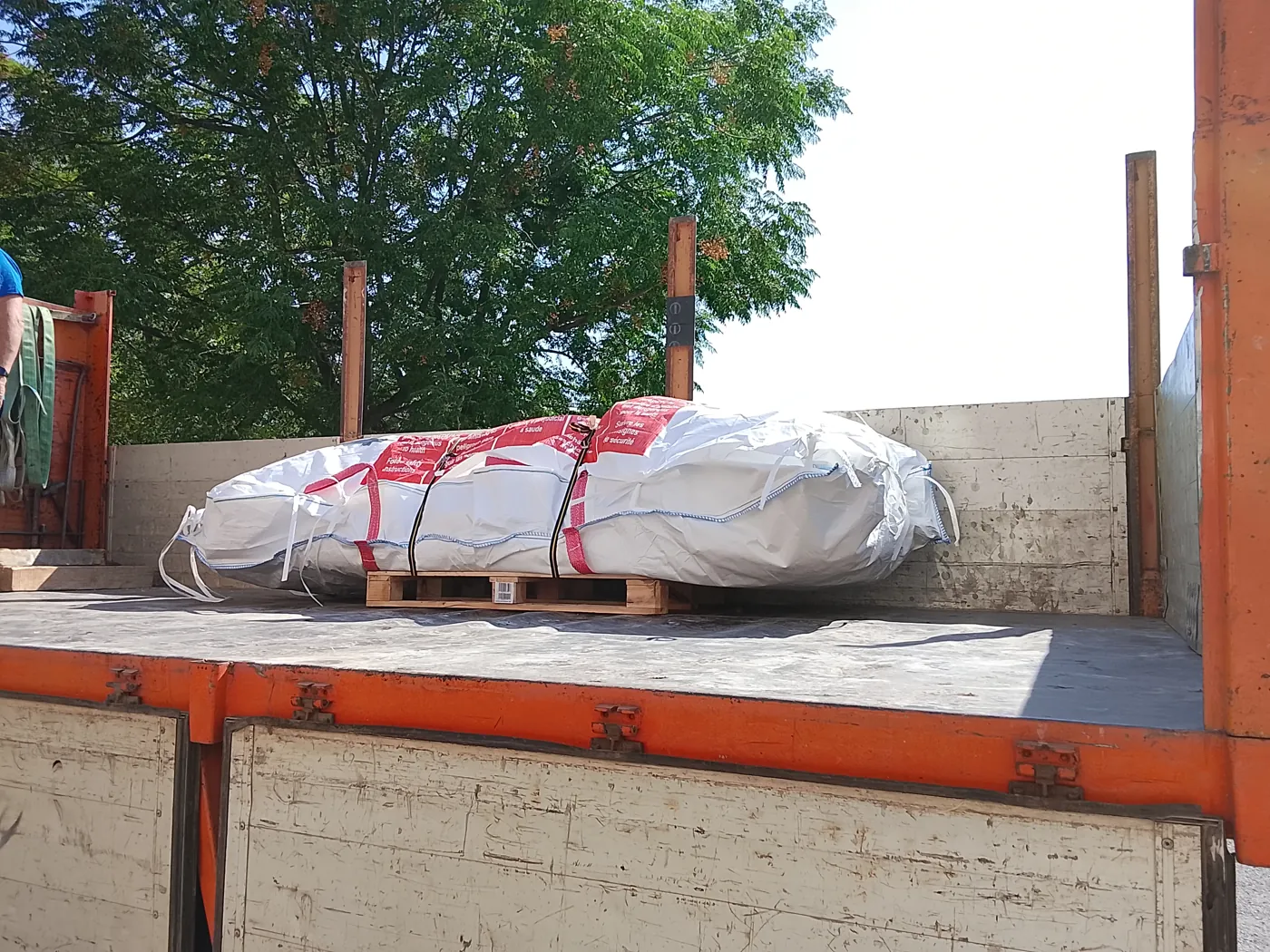 Saca de amianto atada y sobre palé en la caja del camión lista para su transporte
